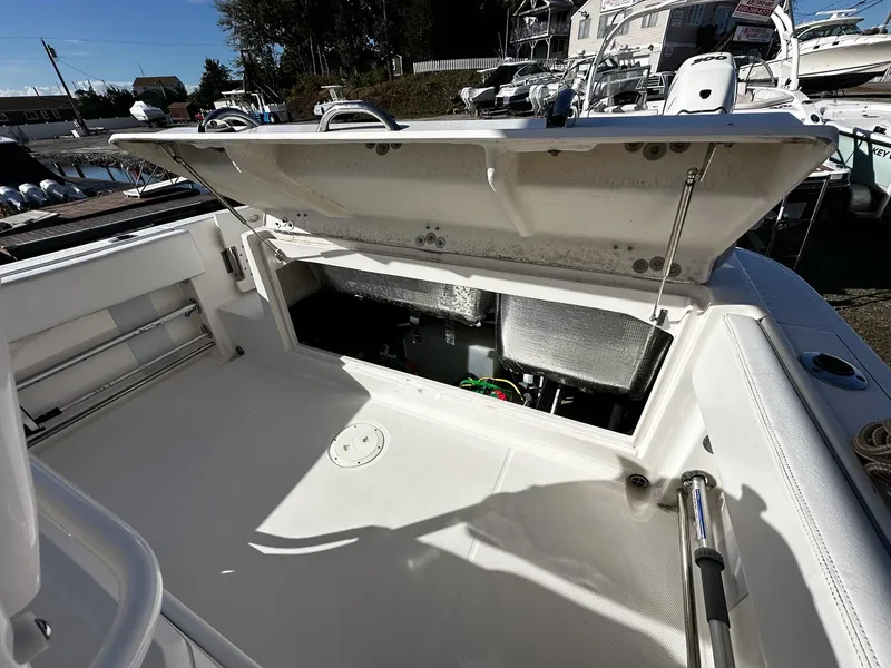 Slide: The Image of 2021 Robalo R242 Center Console boat storage compartment open, showcasing interior space. - 6