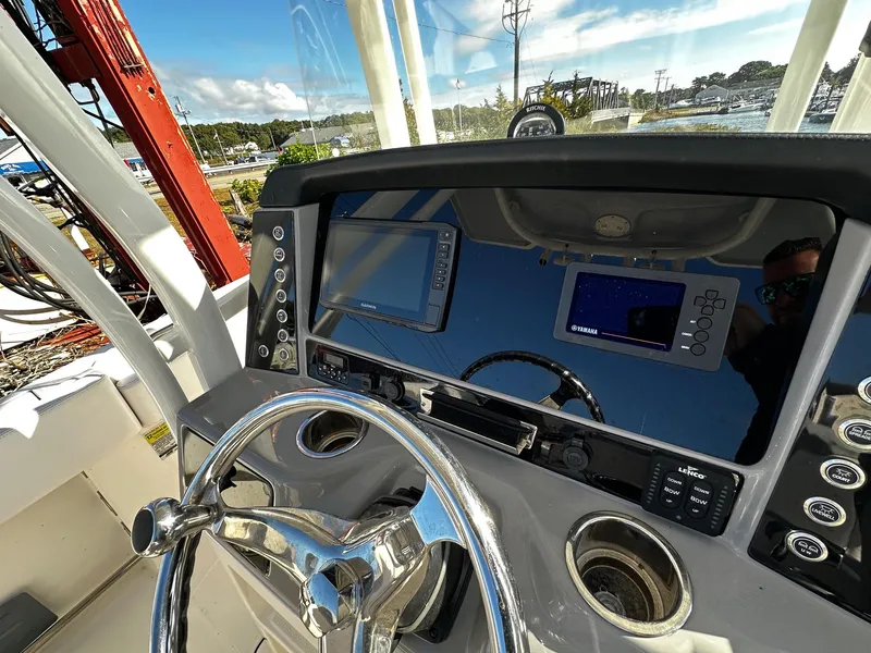 Slide: The Image of 2021 Robalo R242 Center Console helm with steering wheel and navigation displays. - 9