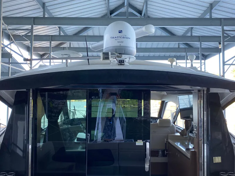 Slide: The Image of 2015 Sea Ray 510 Sundancer yacht with TracVision satellite, docked under a metal roof. - 22