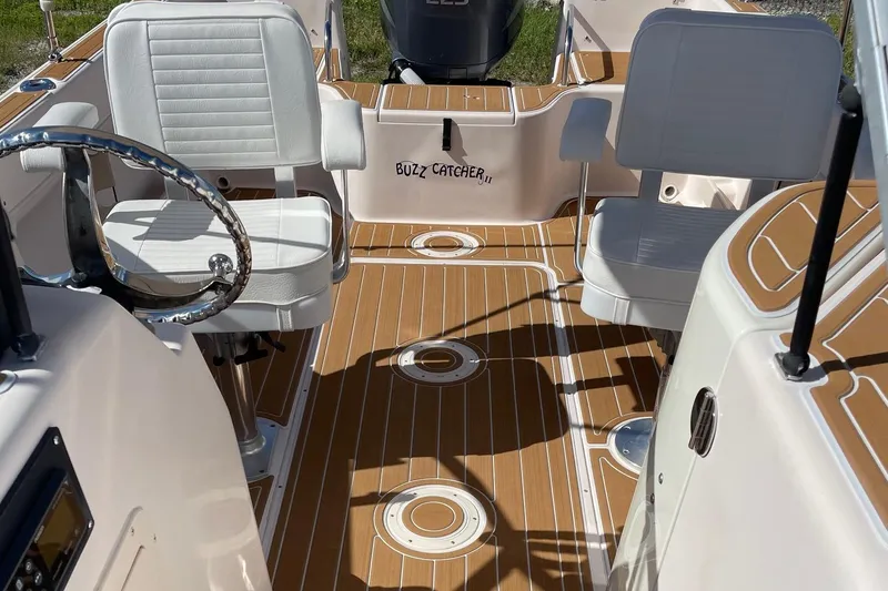 Slide: The Image of 2008 Grady-White Tournament 205 boat interior with white seats and wood-patterned flooring. - 11