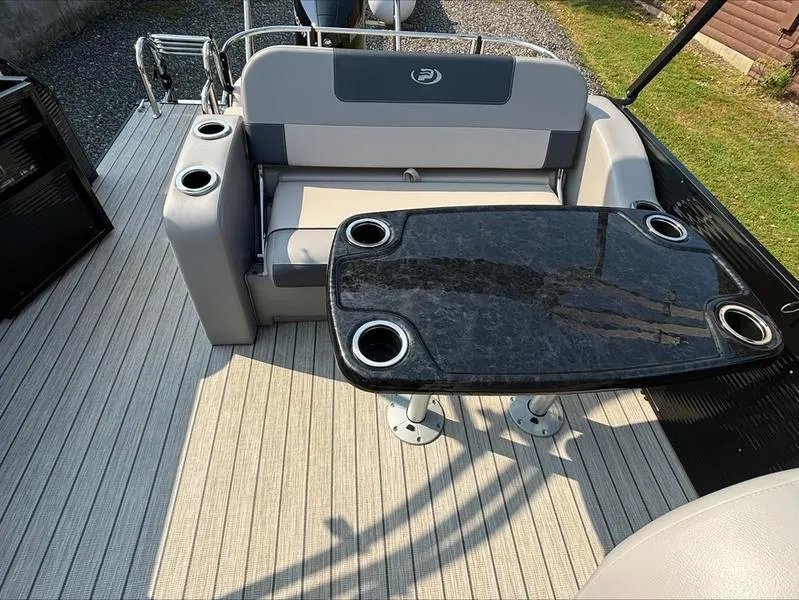 Slide: The Image of 2023 Princecraft QUORUM Q25 boat interior with seating and table, featuring cup holders. - 1
