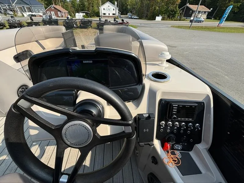 Slide: The Image of 2023 Princecraft QUORUM Q25 boat dashboard with steering wheel and control panel. - 2