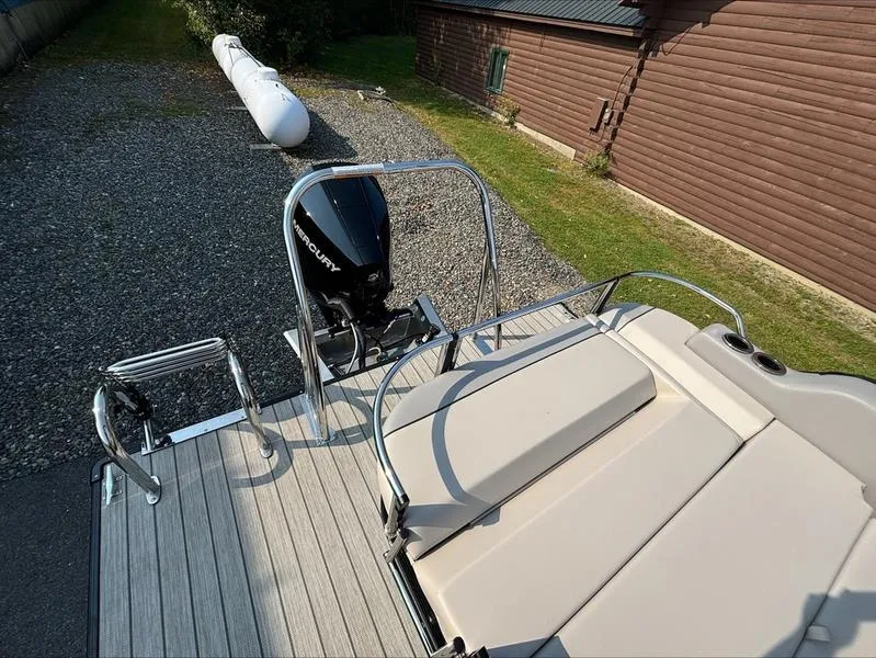 Slide: The Image of 2023 Princecraft QUORUM Q25 boat with Mercury outboard motor, docked near a wooden building. - 3