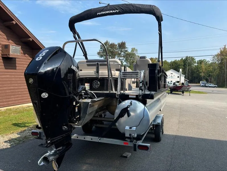 Slide: The Image of 2023 Princecraft QUORUM Q25 pontoon boat on trailer, parked outdoors. - 4