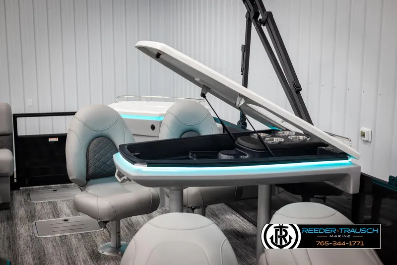 Slide: The Image of 2025 Bennington 23 SXPDSE boat interior with open storage, modern seating, and ambient lighting. - 21