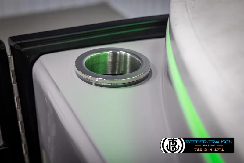 Slide: The Image of 2025 Bennington 23 SXPDSE boat detail with cup holder and green accent lighting. - 45
