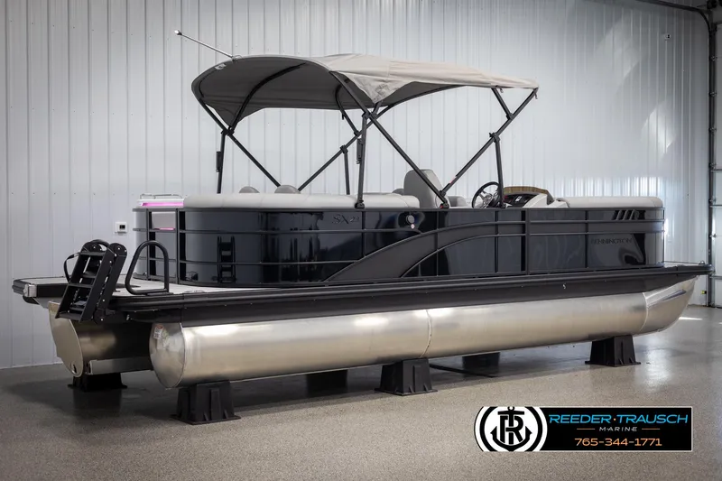 Slide: The Image of 2025 Bennington 23 SXPDSE pontoon boat in showroom, featuring sleek design and canopy. - 6