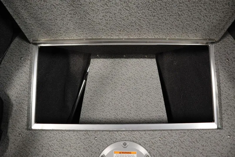 Slide: The Image of Crestliner 1850 Super Hawk JS 2025 storage compartment with gray carpet interior. - 16