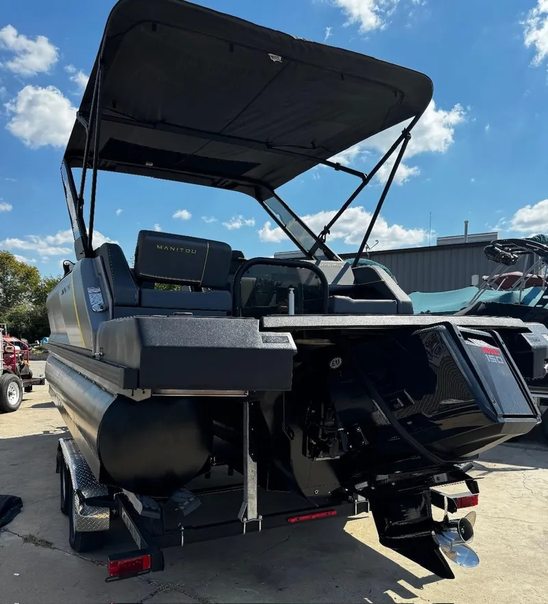 Slide: The Image of 2024 Manitou Explore boat with canopy, docked under a clear blue sky. - 5