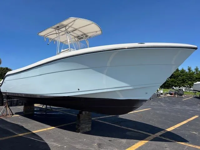 Slide: The Image of 2021 Cobia 237 Center Console boat on display in a parking lot. - 15