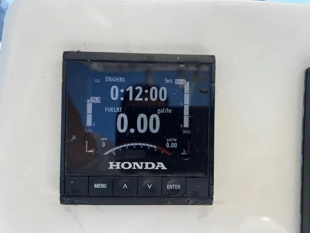 Slide: The Image of Honda engine display on 2021 Cobia 237 Center Console boat, showing 12 engine hours. - 19