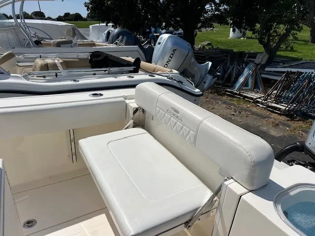 Slide: The Image of 2021 Cobia 237 Center Console boat with white seating and Honda outboard motor. - 21