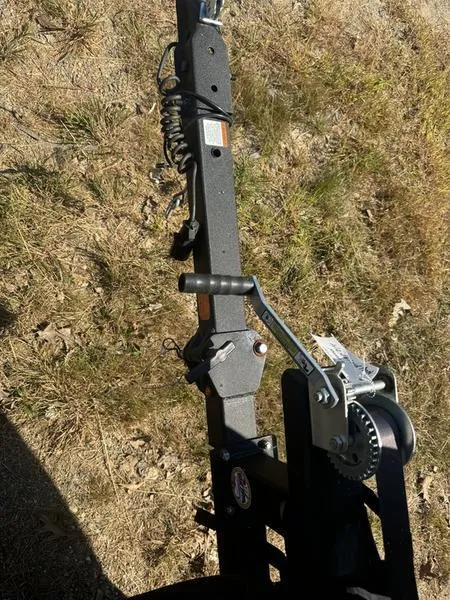 Slide: The Image of 2022 Tahoe T16 trailer hitch with winch on grassy ground. - 2