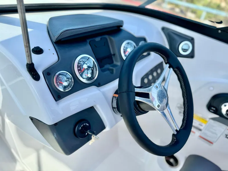 Slide: The Image of 2022 Tahoe 210 S boat dashboard with steering wheel and gauges. - 14