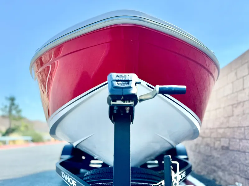 Slide: The Image of 2022 Tahoe 210 S boat on trailer, red and white hull, sunny day. - 2