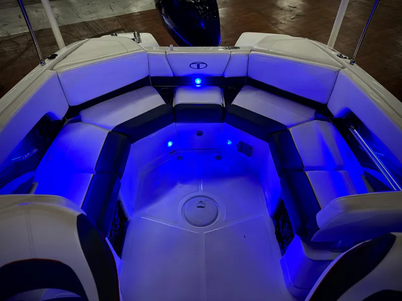 Slide: The Image of 2022 Tahoe 210 S boat interior with blue LED lighting and cushioned seating. - 21