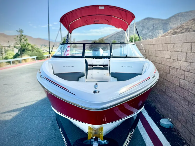 Slide: The Image of 2022 Tahoe 210 S boat with red canopy, parked on a scenic road. - 3