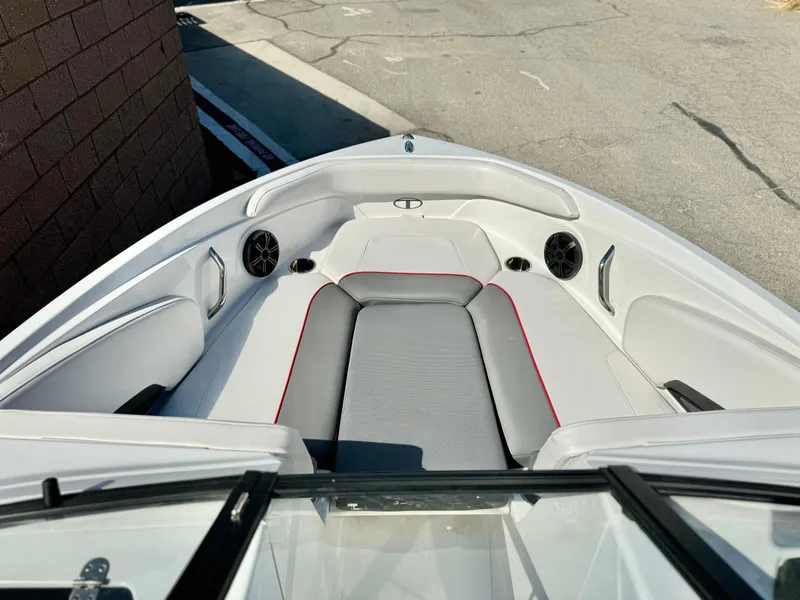 Slide: The Image of 2022 Tahoe 210 S boat interior with gray and white seating, red accents, and speakers. - 9