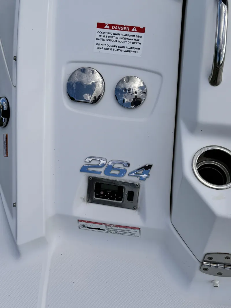 Slide: The Image of 2012 Chaparral 264 Sunesta boat dashboard with warning label and controls. - 11