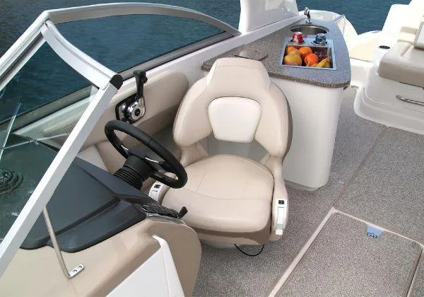 Slide: The Image of 2012 Chaparral 264 Sunesta boat interior with helm seat and fruit tray. - 17