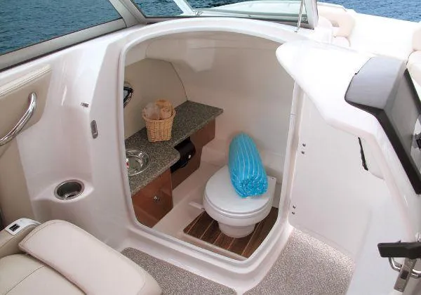Slide: The Image of 2012 Chaparral 264 Sunesta boat interior with compact bathroom and sink. - 19