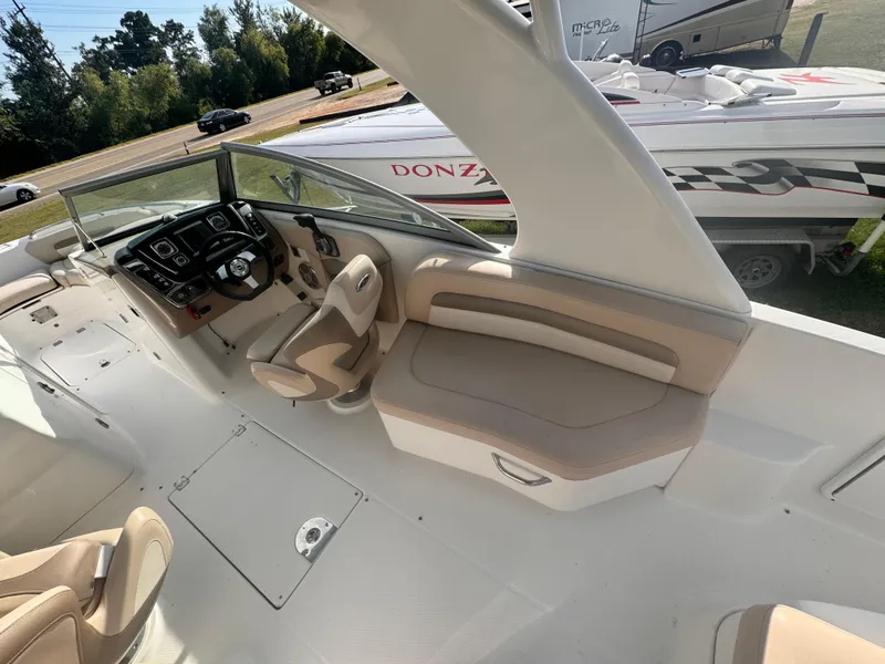 Slide: The Image of 2012 Chaparral 264 Sunesta boat interior with steering console and seating area. - 6