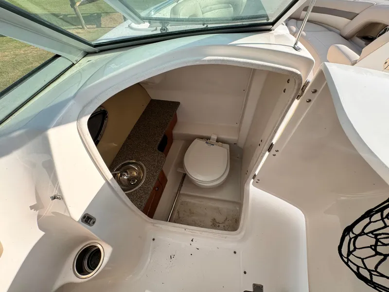 Slide: The Image of 2012 Chaparral 264 Sunesta boat interior with compact bathroom and sink. - 9