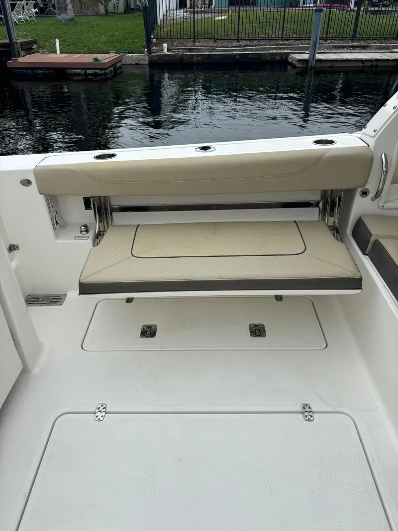 Slide: The Image of 2020 Pursuit 325 Dual Console boat interior with foldable seating by the water. - 11