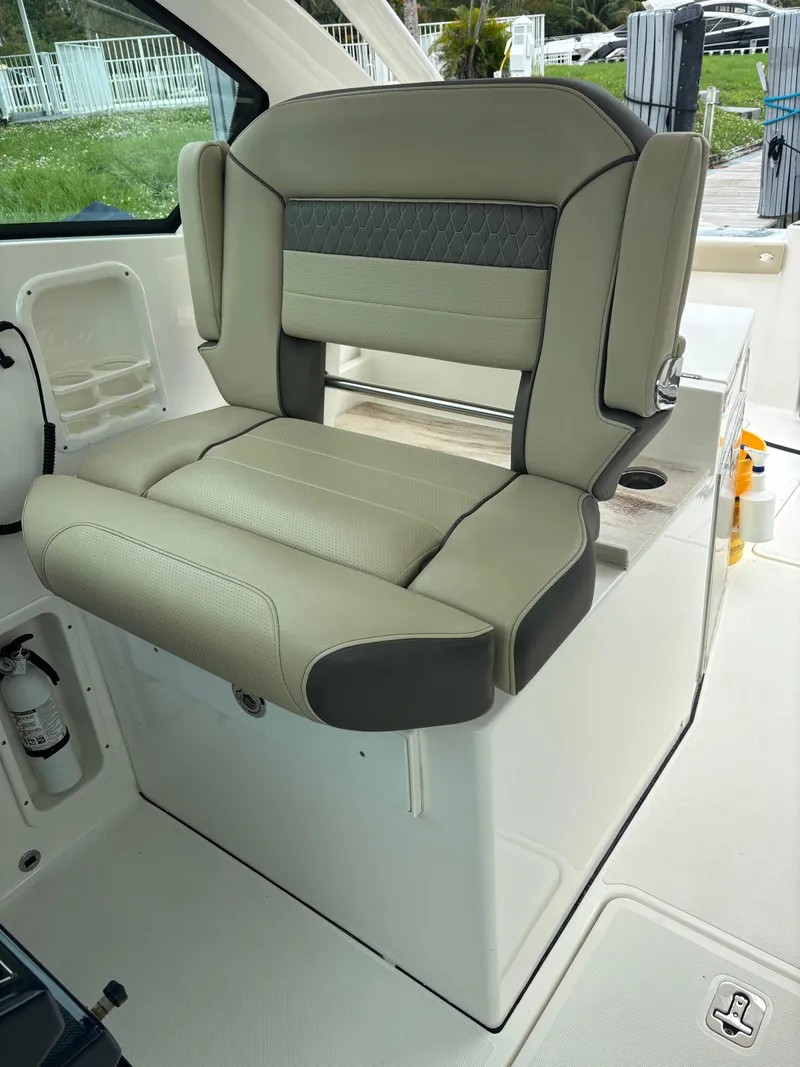 Slide: The Image of 2020 Pursuit 325 Dual Console boat seat, beige and gray upholstery, interior view. - 17