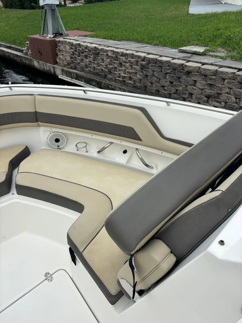 Slide: The Image of 2020 Pursuit 325 Dual Console boat with beige seating near a stone dock. - 29