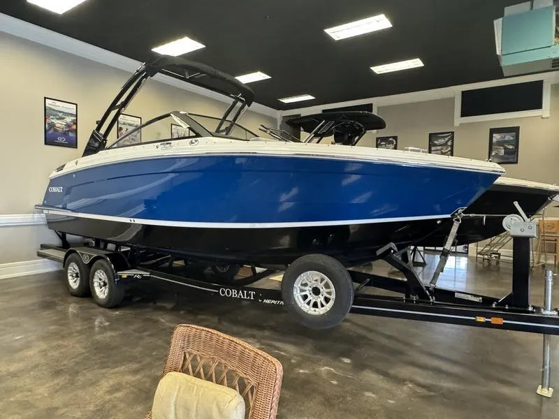 Slide: The Image of 2025 Cobalt R6 boat on trailer in showroom, blue and white design. - 22