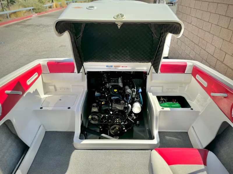 Slide: The Image of 2013 Bayliner 185 Bowrider engine compartment with red and white interior. - 12
