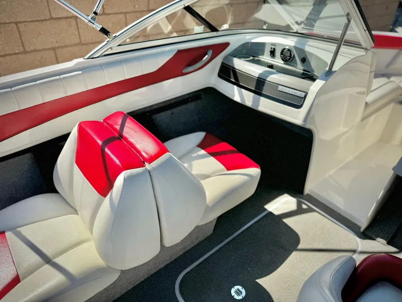 Slide: The Image of 2013 Bayliner 185 Bowrider interior with red and white seating, dashboard view. - 18