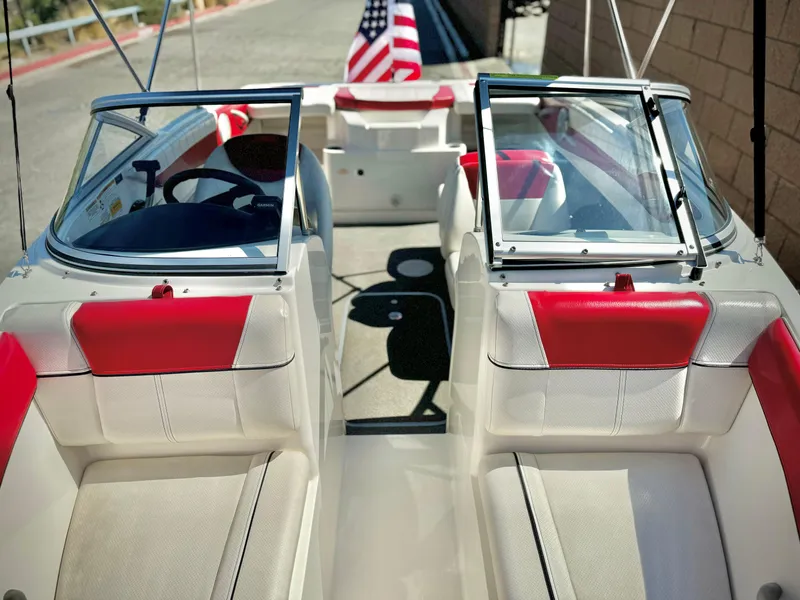 Slide: The Image of 2013 Bayliner 185 Bowrider interior with red and white seating, American flag visible. - 8
