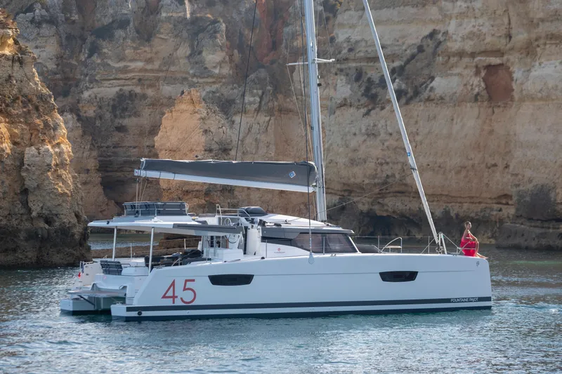 Slide: The Image of 2025 Fountaine Pajot Elba 45 catamaran sailing near rocky cliffs. - 1