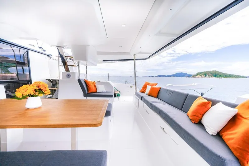 Slide: The Image of Luxurious 2025 Fountaine Pajot Tanna 47 yacht interior with ocean view, featuring elegant seating and decor. - 11
