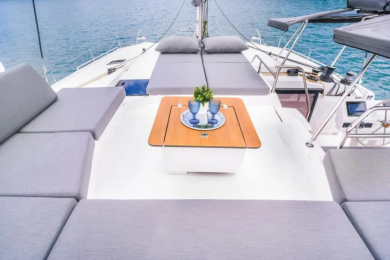 Slide: The Image of Luxurious deck of 2025 Fountaine Pajot Tanna 47 catamaran with elegant seating and table. - 14