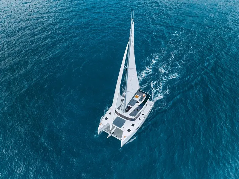 Slide: The Image of 2025 Fountaine Pajot Tanna 47 sailing on open blue sea, aerial view. - 2