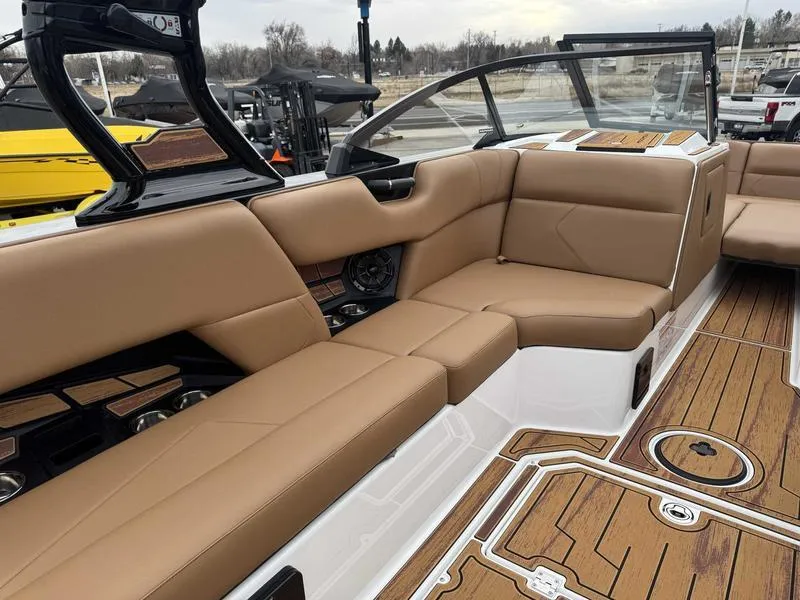 Slide: The Image of 2025 Moomba Tykon boat interior with tan seating and wood accents. - 10