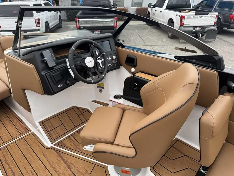 Slide: The Image of 2025 Moomba Tykon boat interior with tan seats, modern dashboard, and steering wheel. - 11
