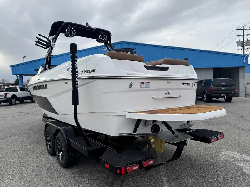 Slide: The Image of 2025 Moomba Tykon boat on trailer, parked outdoors near blue building. - 5