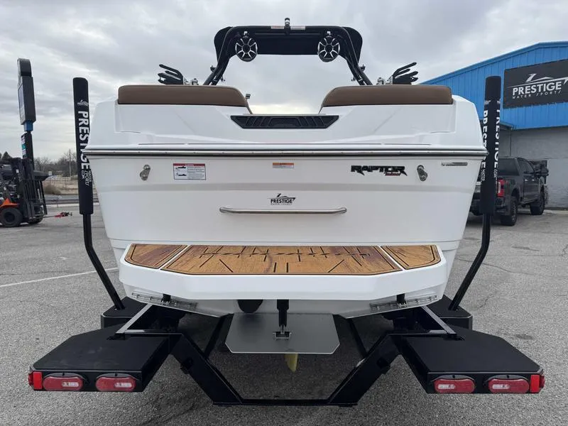 Slide: The Image of 2025 Moomba Tykon boat rear view with Raptor engine, parked at Prestige dealership. - 8