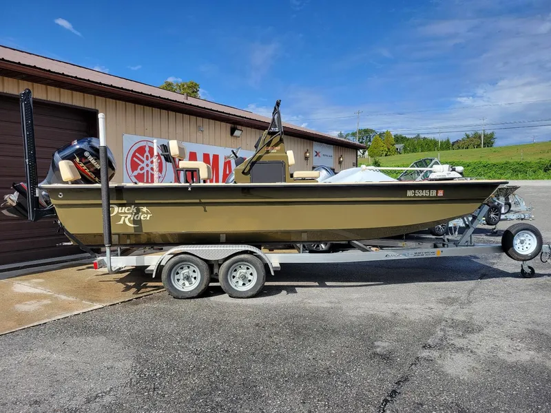 Slide: The Image of 2021 KenCraft Duck Rider 2060 skiff with Yamaha 115, on trailer, parked outside. - 1