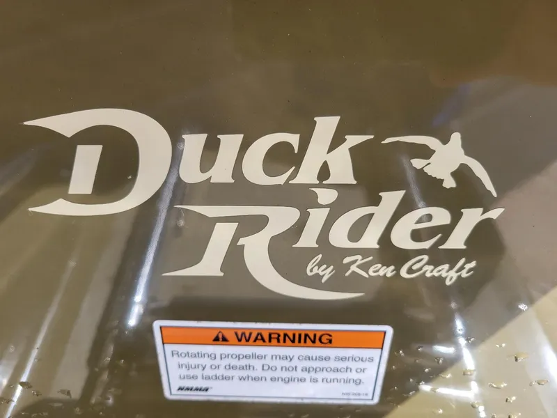 Slide: The Image of KenCraft Duck Rider 2060 logo with safety warning label on boat surface. - 4