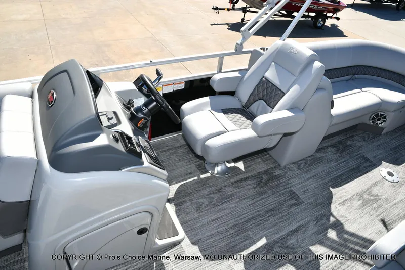 Slide: The Image of 2025 Ranger 243C Cruise boat interior with steering console and plush seating. - 11