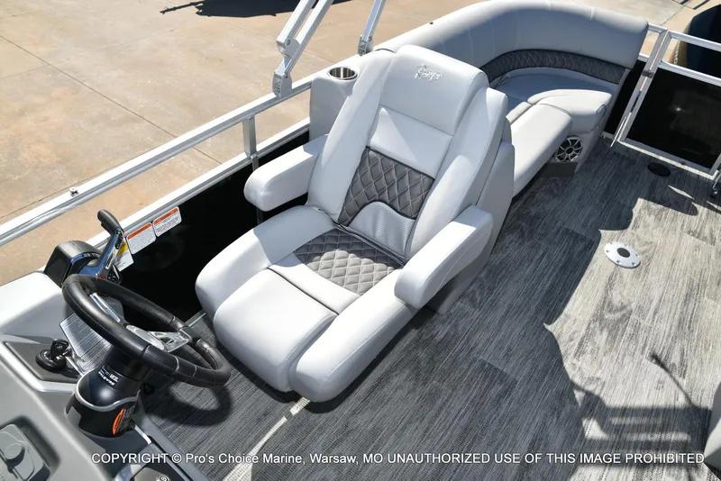 Slide: The Image of 2025 Ranger 243C Cruise boat interior with luxury seating and steering wheel. - 25