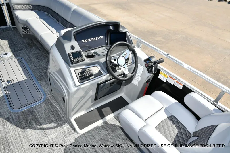 Slide: The Image of 2025 Ranger 243C Cruise boat interior with steering console and seating. - 27