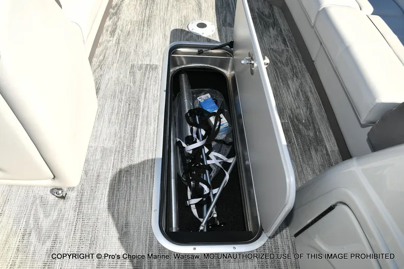 Slide: The Image of Open storage compartment on 2025 Ranger 243C Cruise boat with accessories inside. - 32