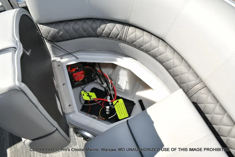 Slide: The Image of 2025 Ranger 243C Cruise boat interior storage compartment with wiring and battery setup. - 47