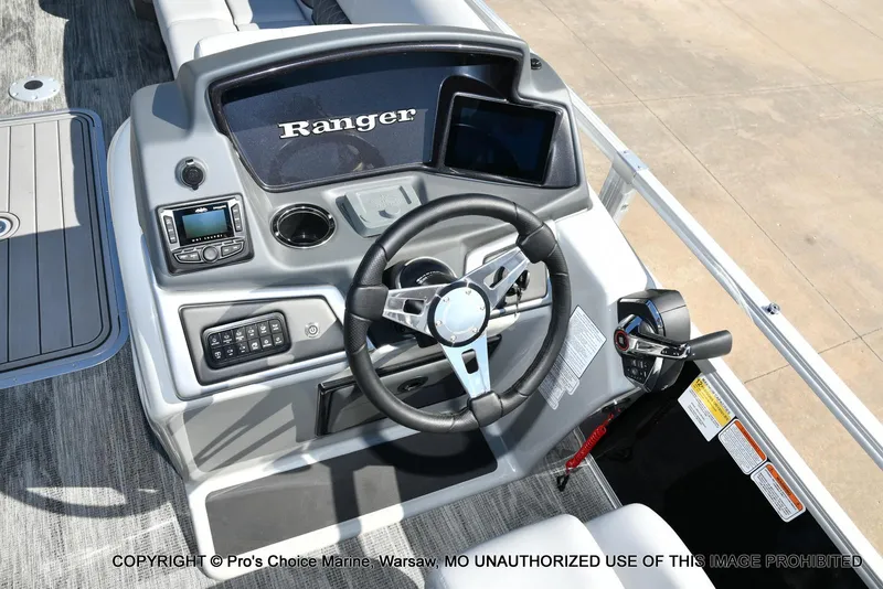 Slide: The Image of 2025 Ranger 243C Cruise boat dashboard with steering wheel and controls. - 6